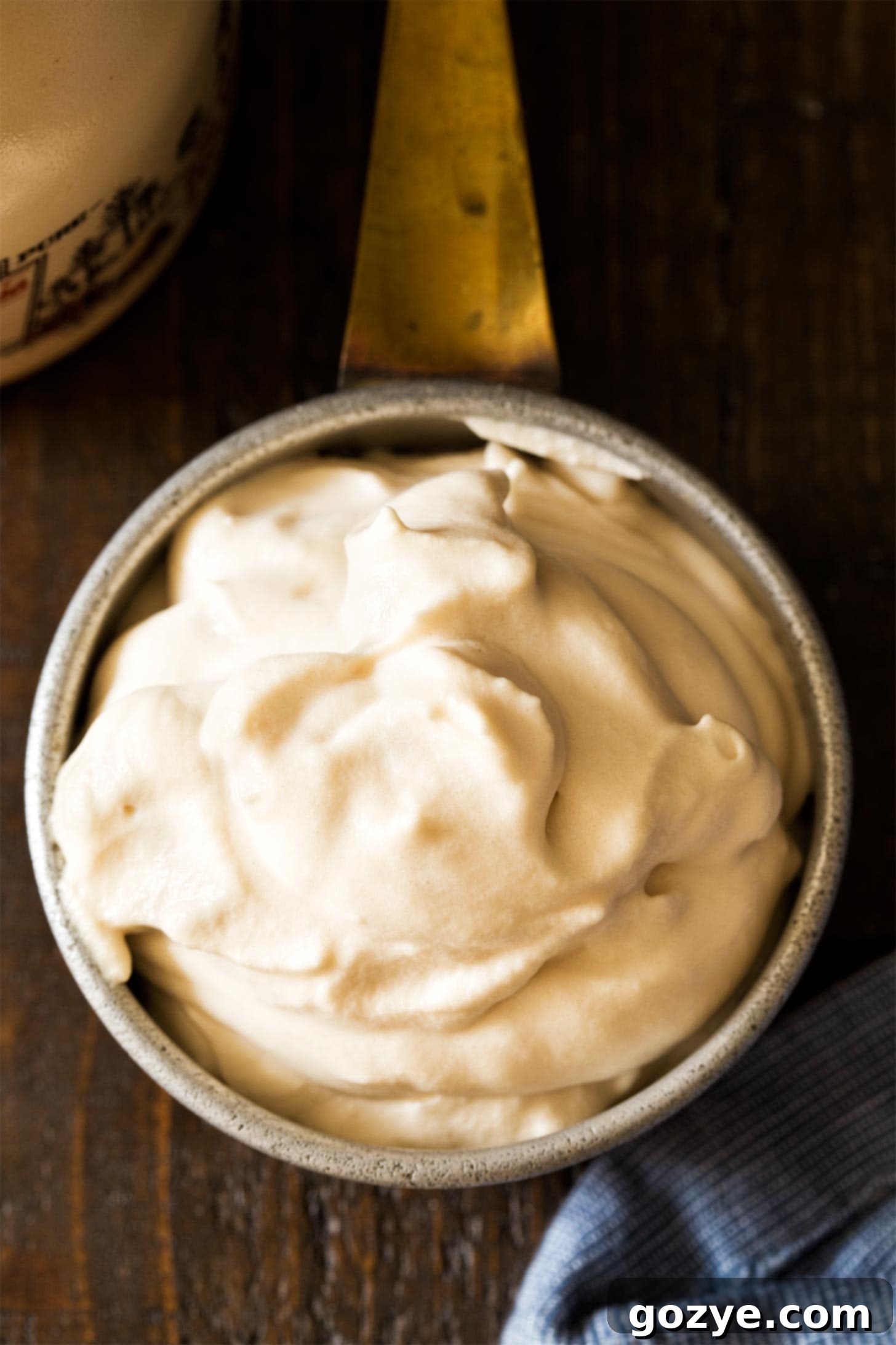 Overhead shot of maple syrup whipped cream in a copper cup, artfully presented and ready for serving