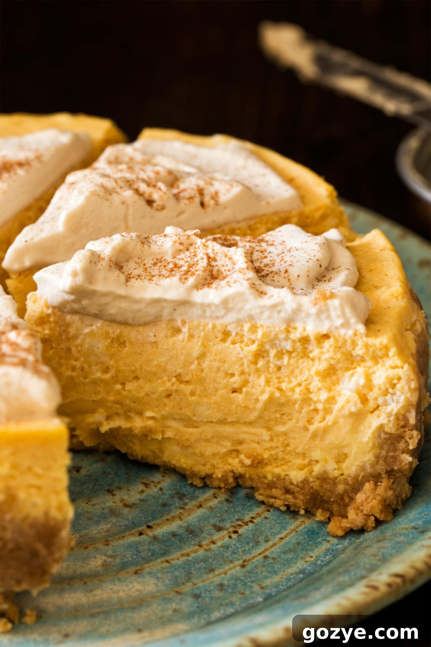 Multiple slices of Instant Pot Pumpkin Cheesecake arranged beautifully on a white plate, showcasing its golden crust and creamy filling.