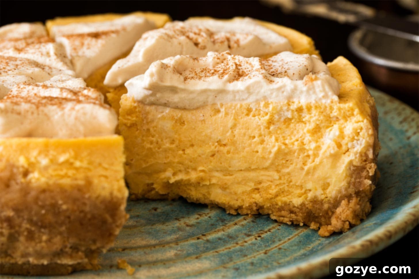 Slices of Instant Pot Pumpkin Cheesecake on a plate, garnished with a sprinkle of cinnamon, showcasing the dessert's readiness.