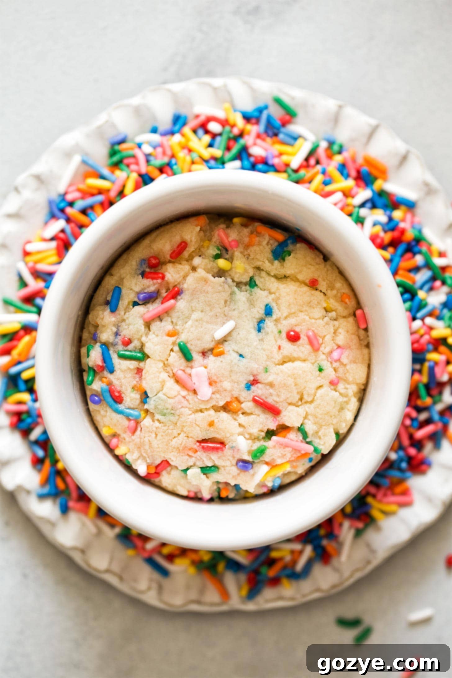 Overhead shot of sugar cookie for one on plate of sprinkles