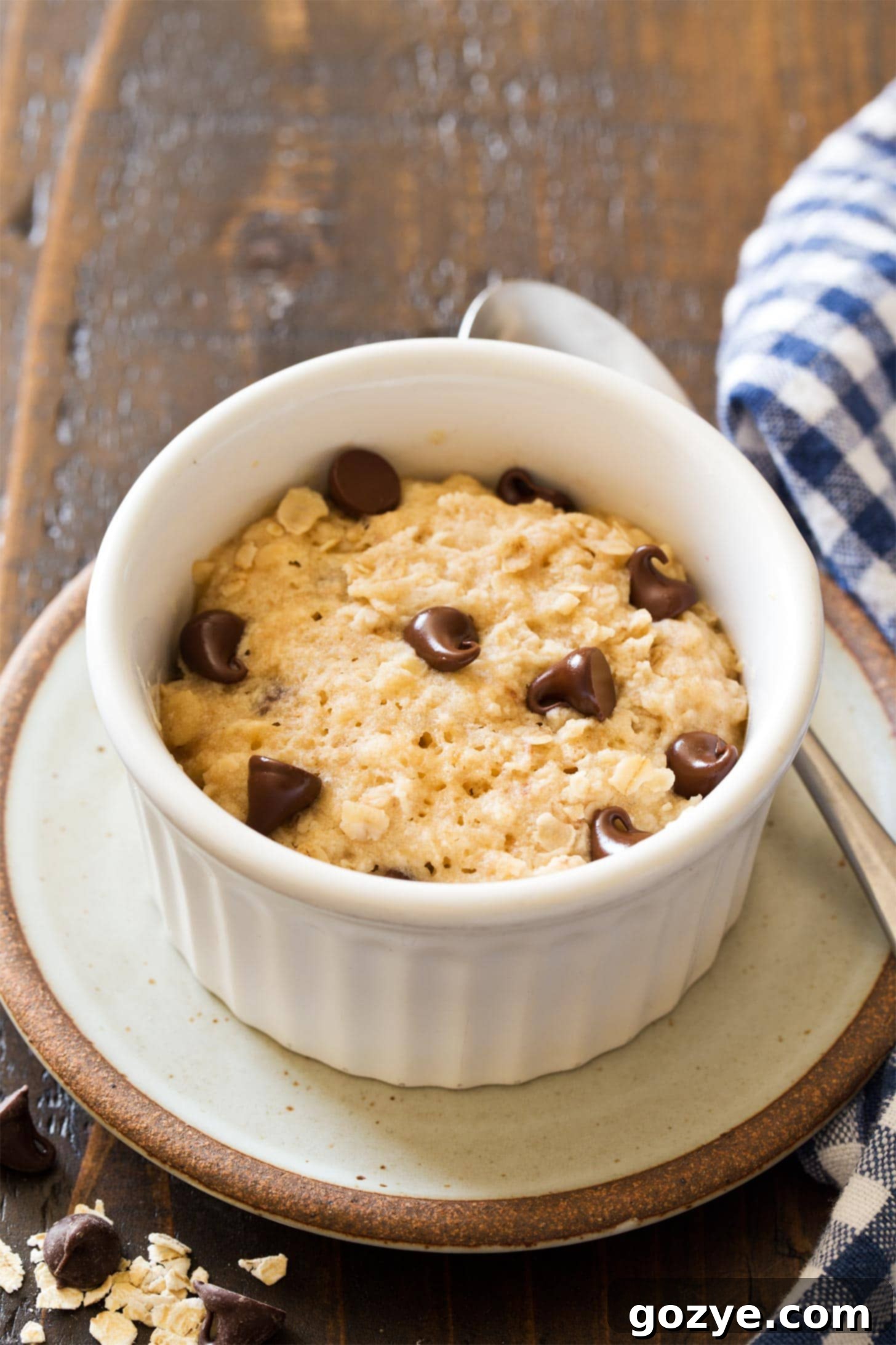 One-Minute Microwave Oatmeal Cookie 14 Microwave oatmeal cookie in white ramekin, perfectly golden brown with melted chocolate chips