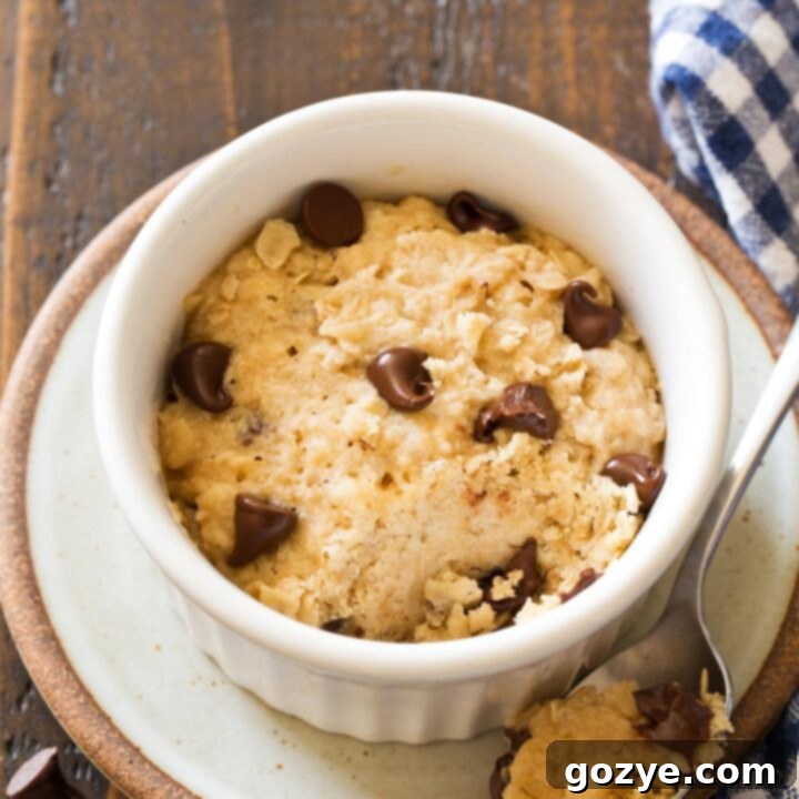 Mug oatmeal cookie with a bite taken out, showcasing the melted chocolate chips and soft interior