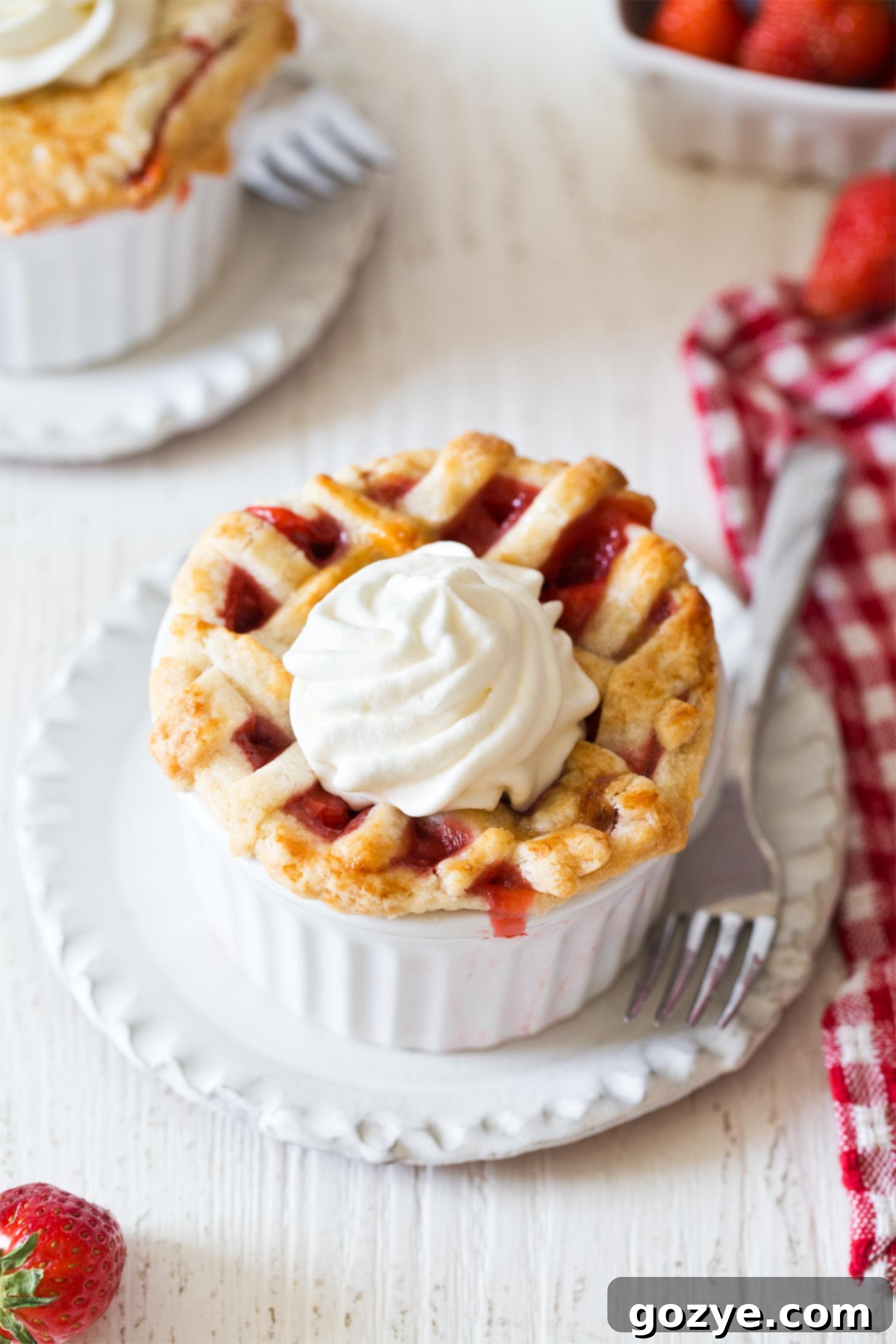 Mini Strawberry Pies with pie crust topped with whipped cream