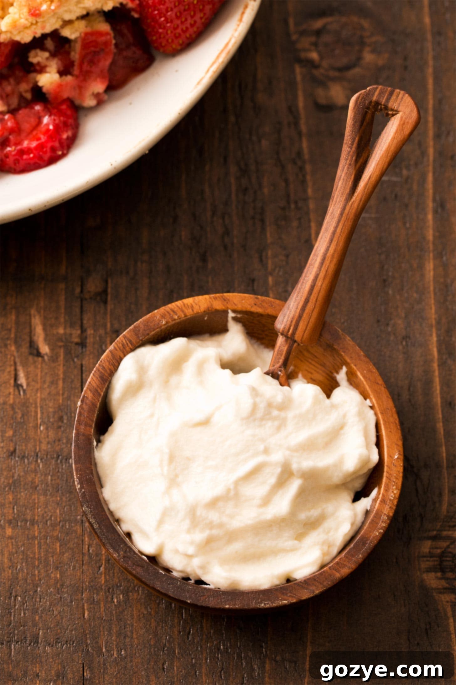 Honey whipped cream in small brown bowl, ready to be served
