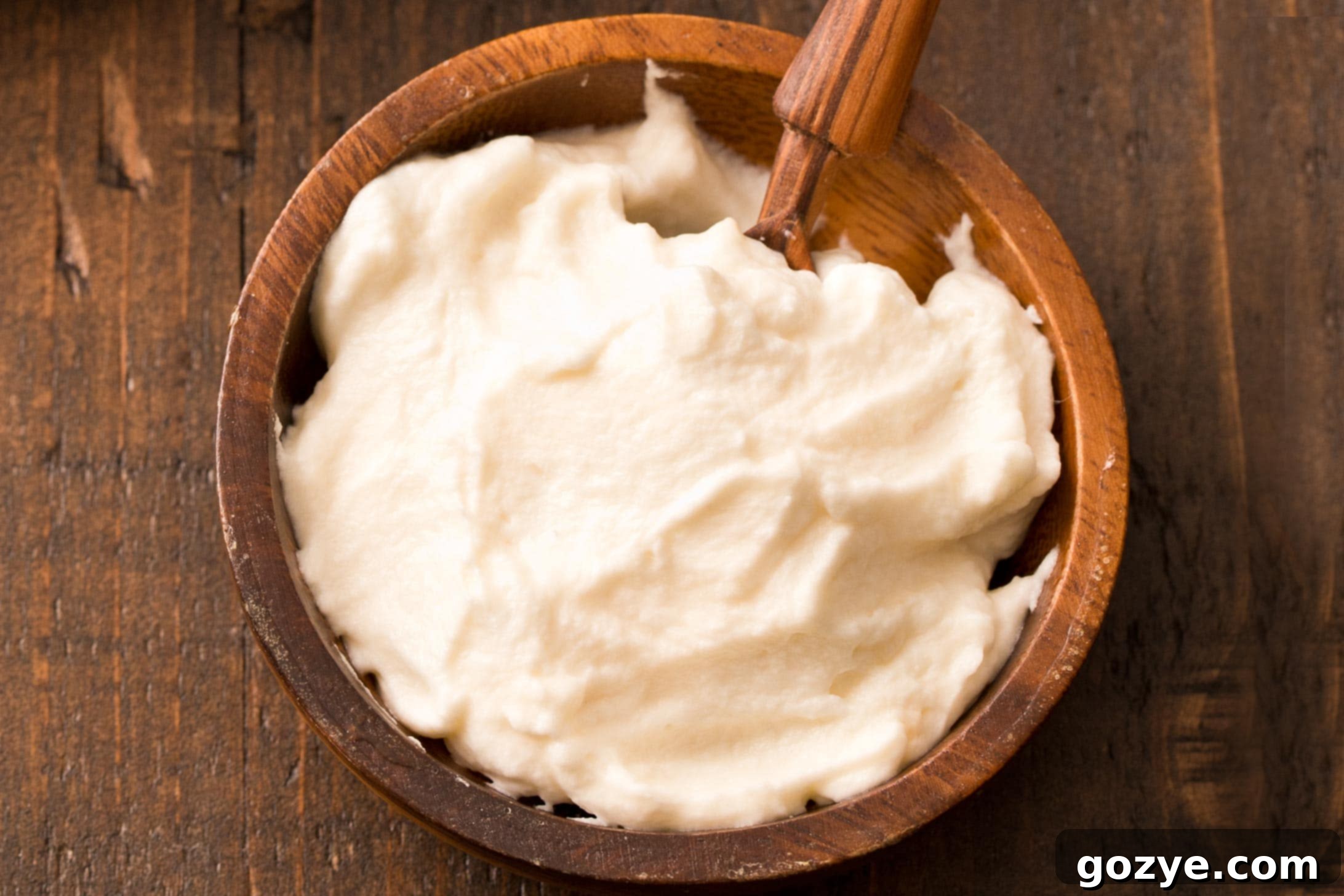 Close up of fluffy whipped honey cream in a rustic brown bowl