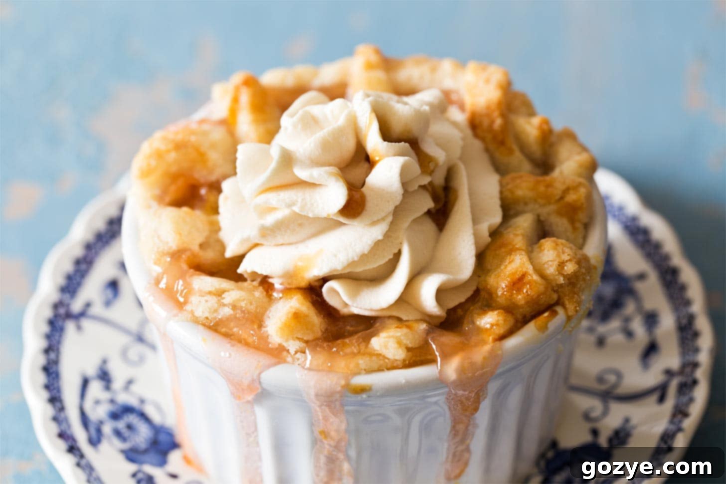 Fluffy honey whipped cream dolloped on a slice of fresh peach pie, garnished with mint