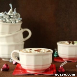 A beautifully garnished mug of Cherry Cordial and Mint Truffle Kiss Hot Chocolate with Marshmallow Whipped Cream.