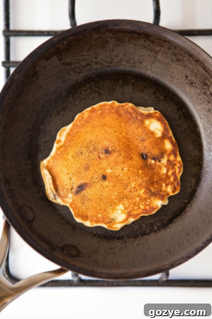 Golden brown chocolate chip pancake in skillet