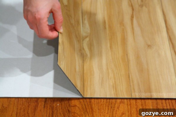 Carefully aligning vinyl plank on poster board