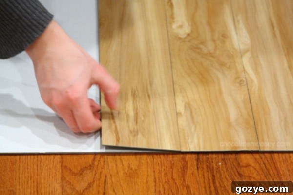 Pressing down vinyl plank to secure adhesion
