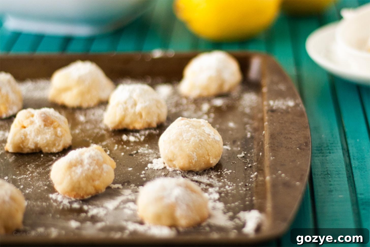 Lemon Snowball Cookies on a cookie tray with lemons