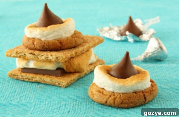 A collection of S'mores Blossom Cookies with perfectly toasted marshmallows and melted chocolate kisses on a baking sheet.