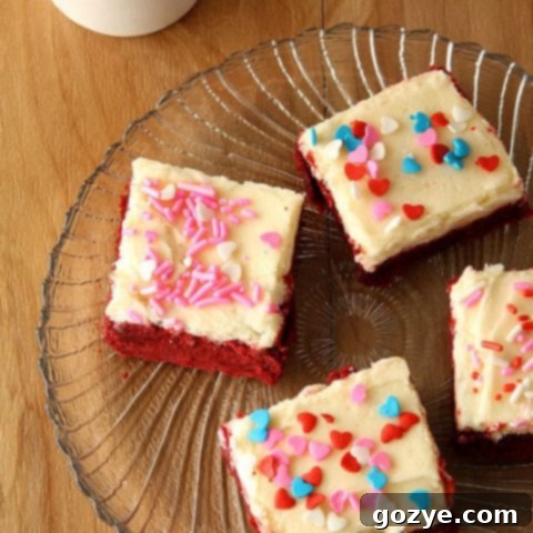Red Velvet Sugar Cookies Bars topped with cream cheese frosting and sprinkles