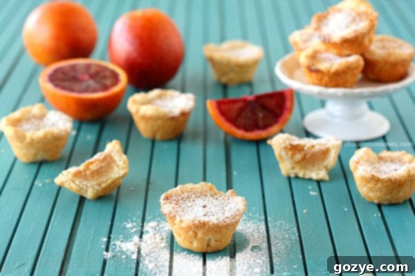 Plate of freshly baked Blood Orange Pie Bites dusted with powdered sugar