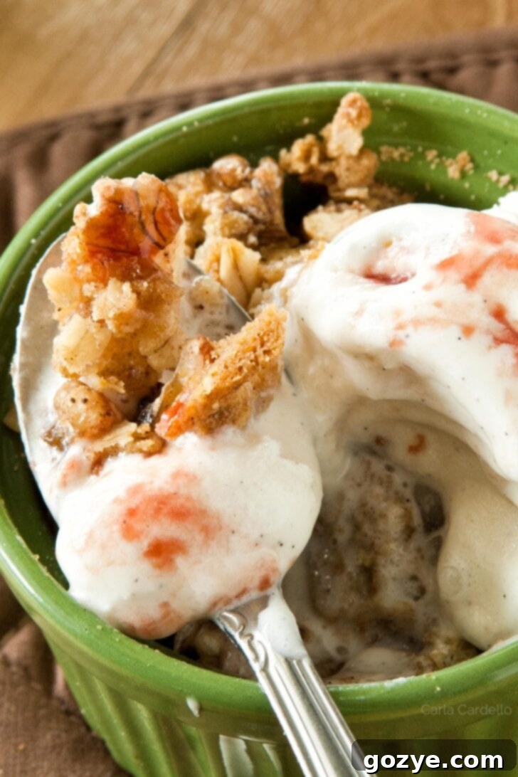 Blood Orange Pear Crisp 4 Spoon with pear crisp and melted vanilla ice cream, indicating a delicious dessert