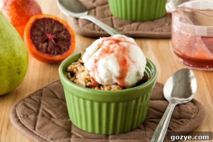 Pear Crisp For Two in a ramekin with vanilla ice cream on top