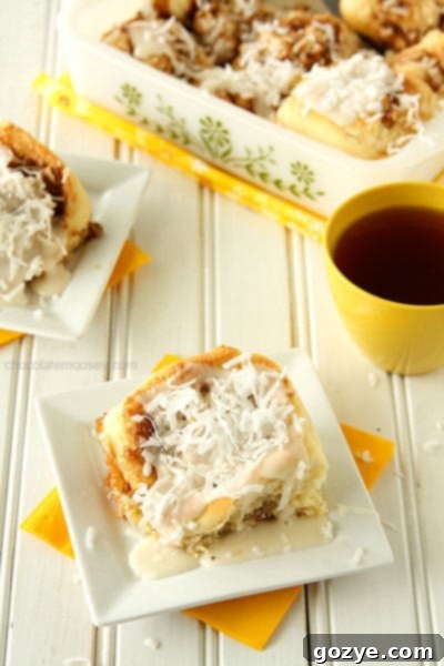 Lemon Coconut Cinnamon Rolls 7 A single Lemon Coconut Cinnamon Roll, topped with glaze and shredded coconut, ready to be eaten.