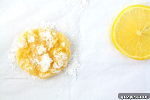 Close-up of baked Lemon Coconut Crinkle Cookies with their distinct powdered sugar coating.
