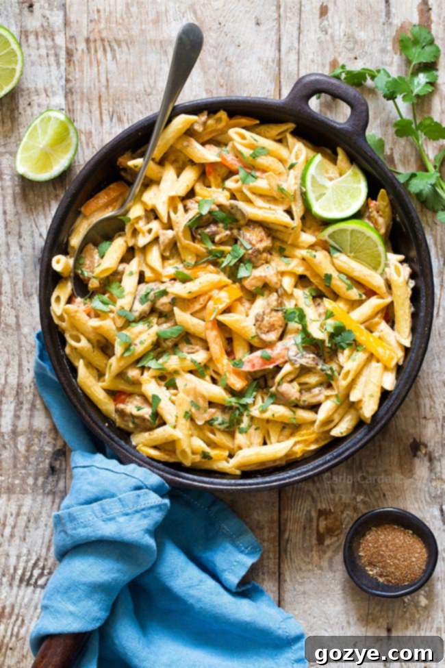 Large skillet filled with creamy Chicken Fajita Pasta, garnished and ready to be served