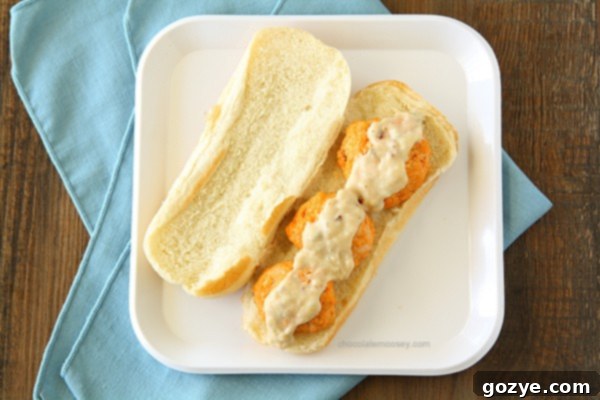 Close-up of buffalo chicken meatballs baking on a sheet pan.