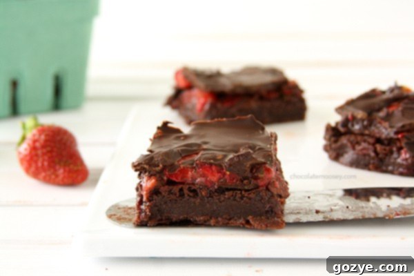 Slices of Chocolate Covered Strawberry Brownies showing the layers of brownie, strawberry, and chocolate