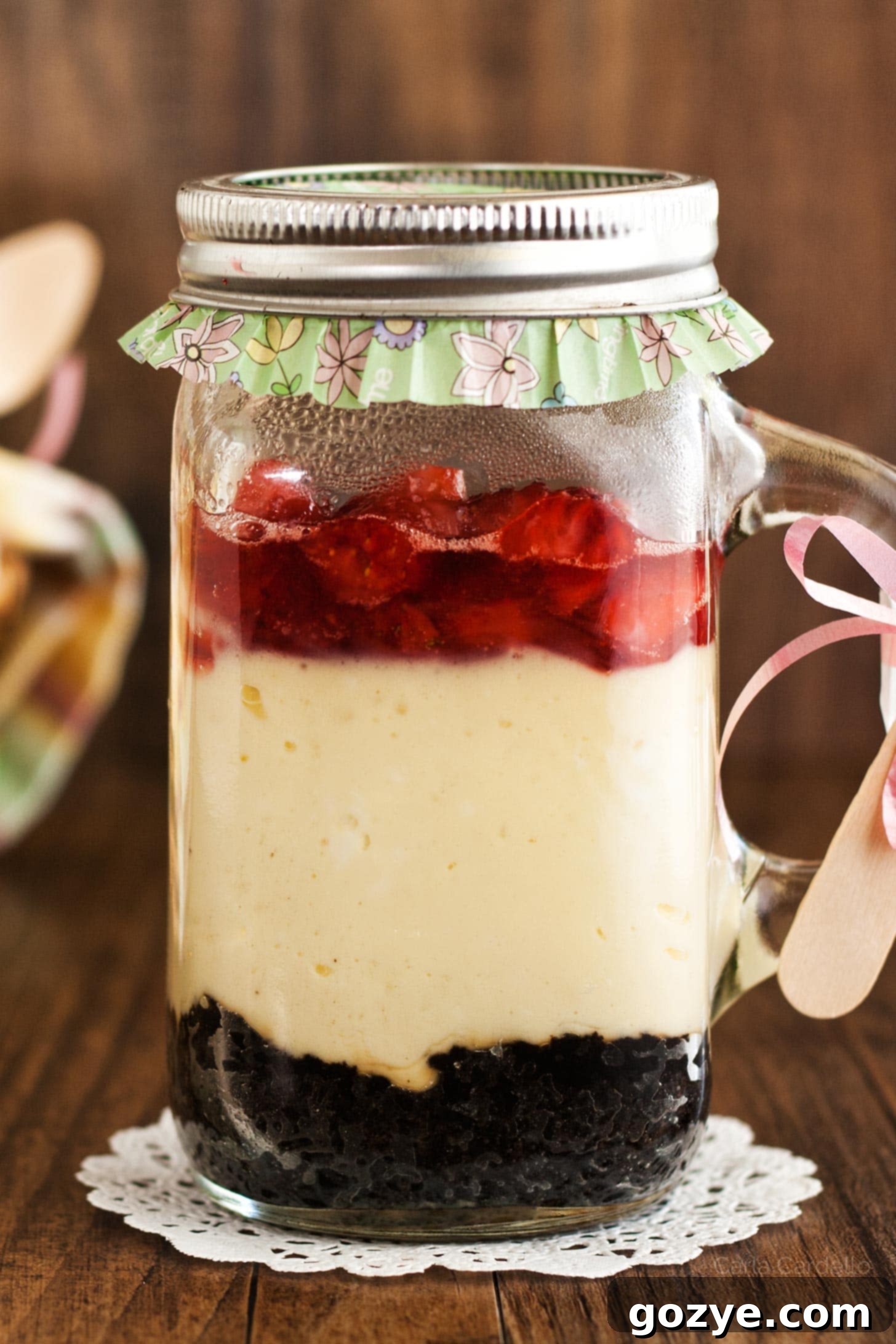 Cheesecake in a jar with Oreo cookie crust and strawberry sauce