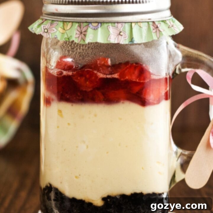 Cheesecake in a jar with Oreo cookie crust and strawberry sauce