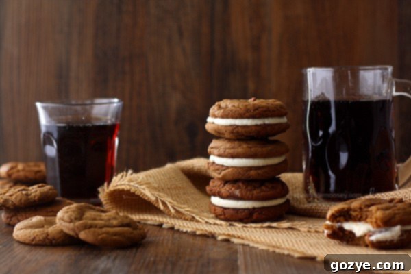 Two Root Beer Float Sandwich Cookies, one whole and one cut in half to show the vanilla cream filling