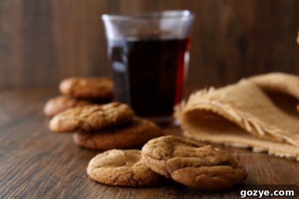 Root Beer Float Sandwich Cookies arranged on a plate with one cookie in hand