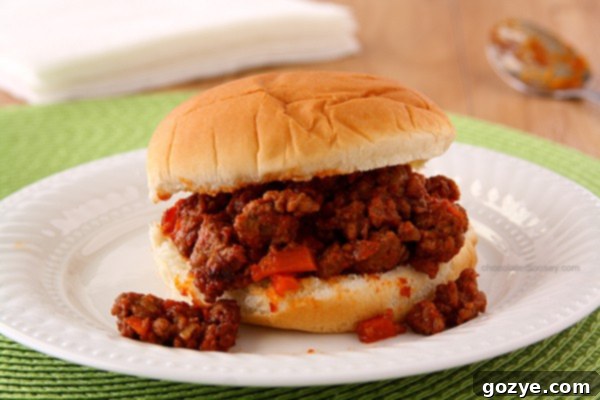 Homemade Sloppy Joe Sandwiches | Close-up of ground beef and carrots simmering in tomato sauce for sloppy joes