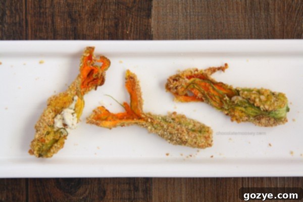 Two Goat Cheese Stuffed Squash Blossoms on a wooden board | chocolatemoosey.com