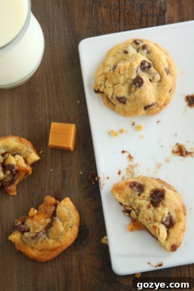 Caramel Stuffed Chocolate Chip Cookies | A Hand Holding a Cookie with Gooey Caramel