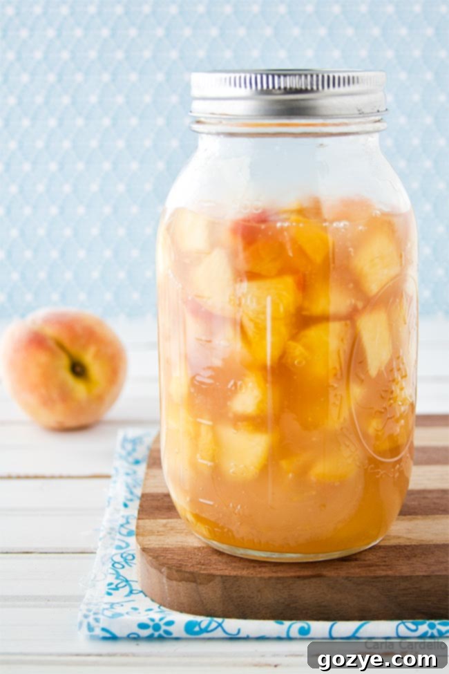 Homemade peach pie filling in a large glass jar, showing rich color and texture