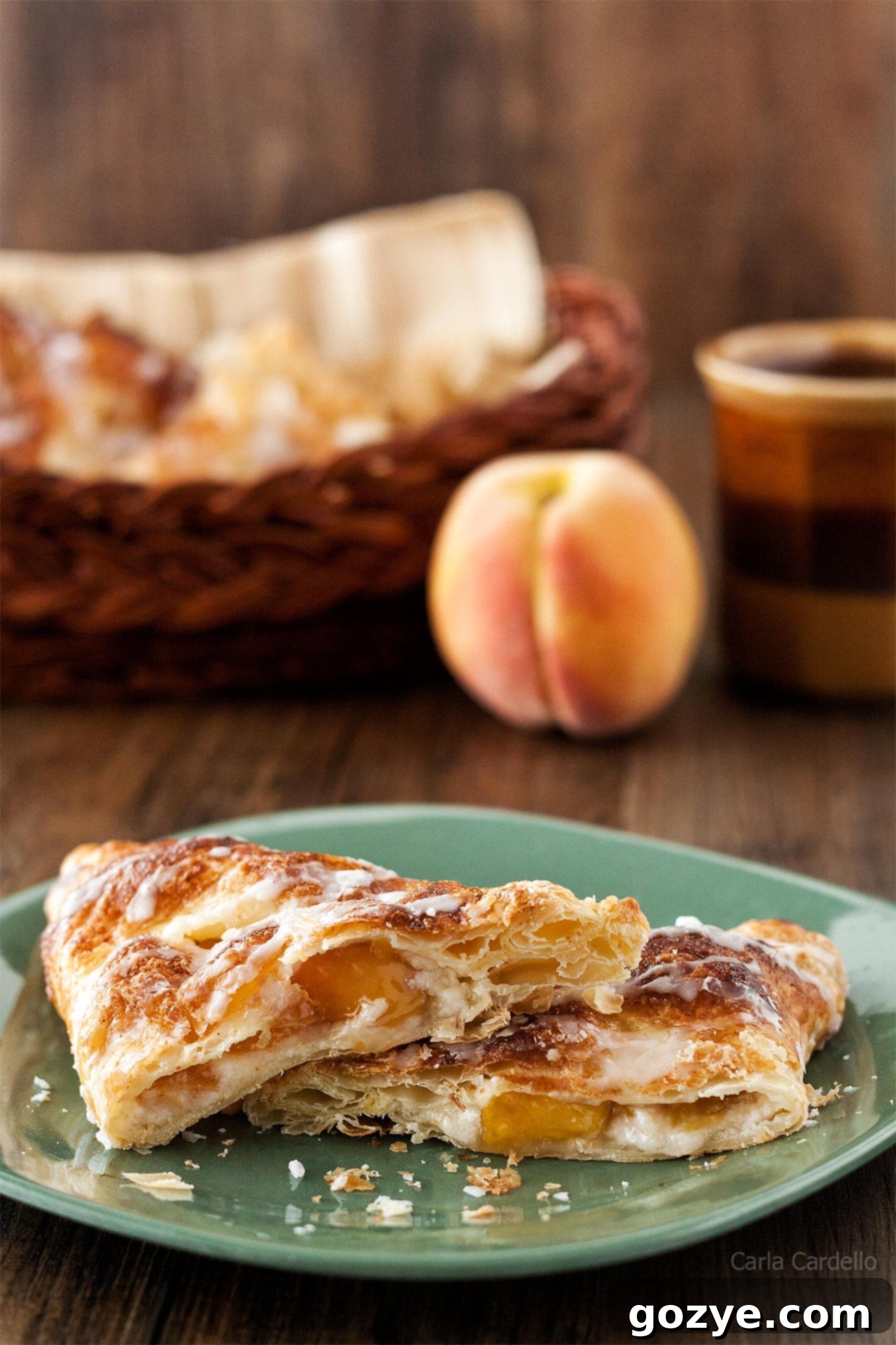 Puff Pastry Peach Turnovers cut in half on a green plate, showing the flaky crust and delicious filling