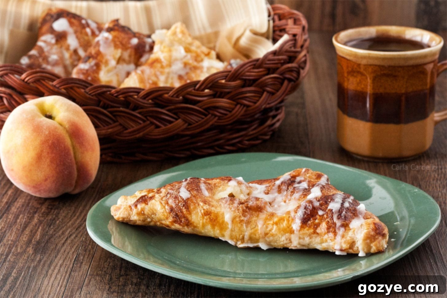 Whole Peach Turnover on a green plate, showing its golden-brown exterior
