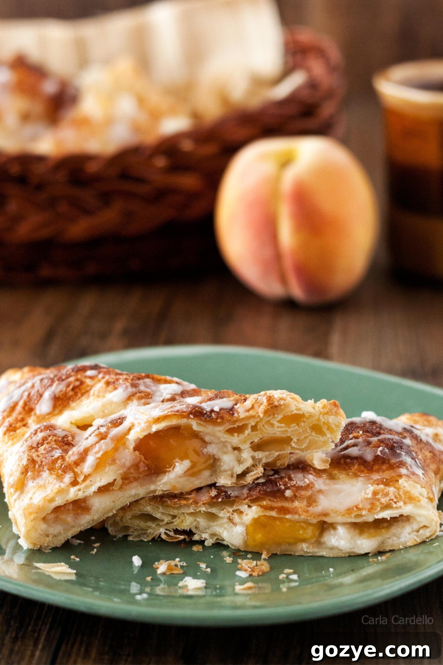 Close up of a peach turnover cut in half, showcasing the creamy cheesecake and peach filling