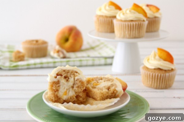 Cross-section of Peaches and Cream Stuffed Cupcakes showing the creamy cheesecake filling