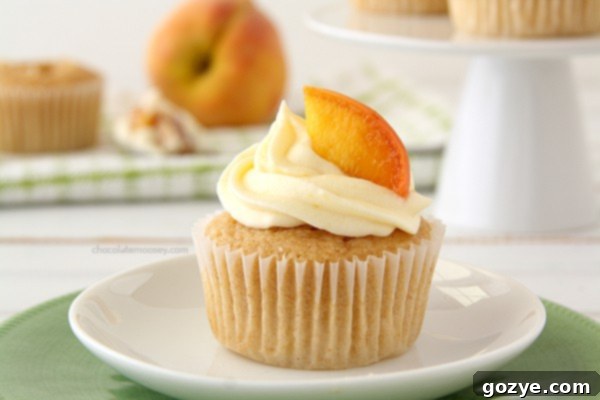 A display of several Peaches and Cream Stuffed Cupcakes with fresh peach slices