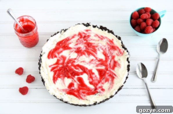 Delicious Raspberry Swirl Cheesecake Tart with an Oreo crust, perfect for summer. Learn how to make this impressive dessert.