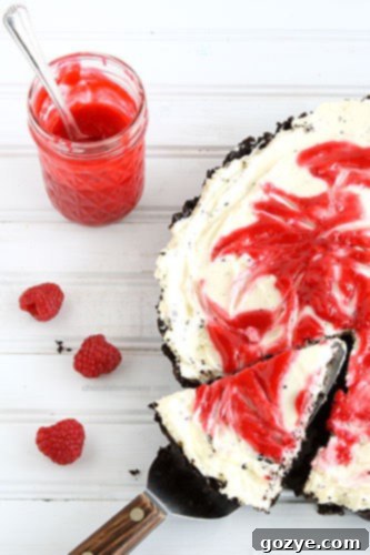 Section of the Raspberry Swirl Cheesecake Tart showcasing the thick, creamy cheesecake layer and the raspberry curd.