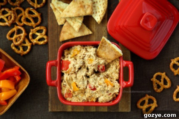 A bowl of Chicken Fajita Dip served with various dippers like nachos and bell pepper strips