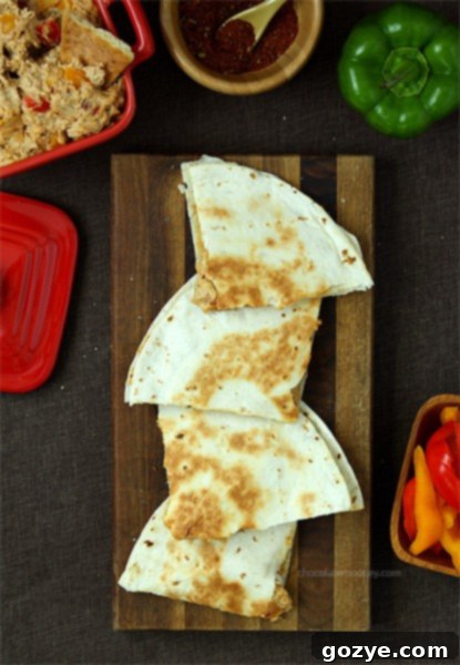 Half of a quesadilla showing the cheesy Chicken Fajita Dip filling