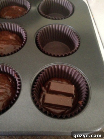 Process of filling Kit Kat Cupcakes with batter and candy
