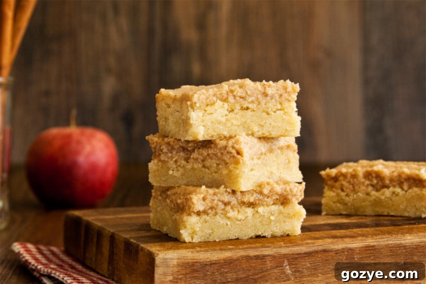 Snickerdoodle cookie bar recipe on a cutting board with several squares cut and some removed