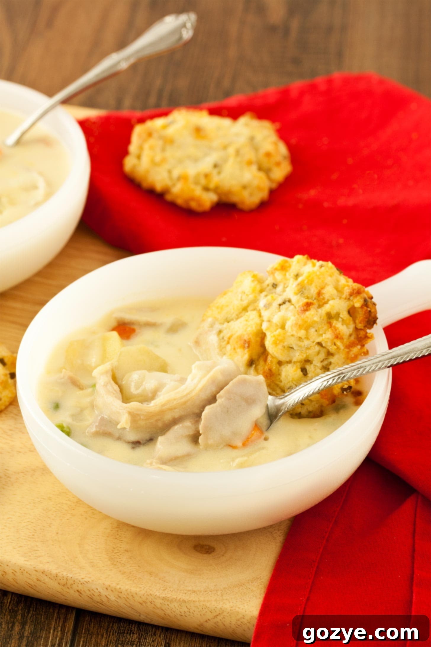 Hearty chicken pot pie soup with a spoon, showing creamy texture and vegetables