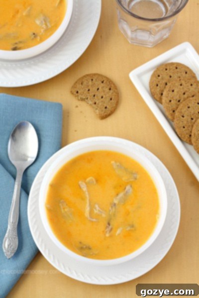 Close-up of a spoonful of Cheesy Buffalo Chicken Soup, showcasing the cheesy texture and chicken pieces.