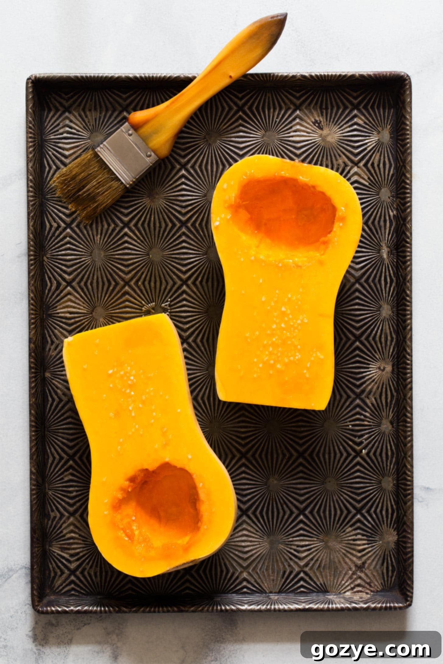 Brushing the cut side of butternut squash halves generously with olive oil before seasoning and roasting