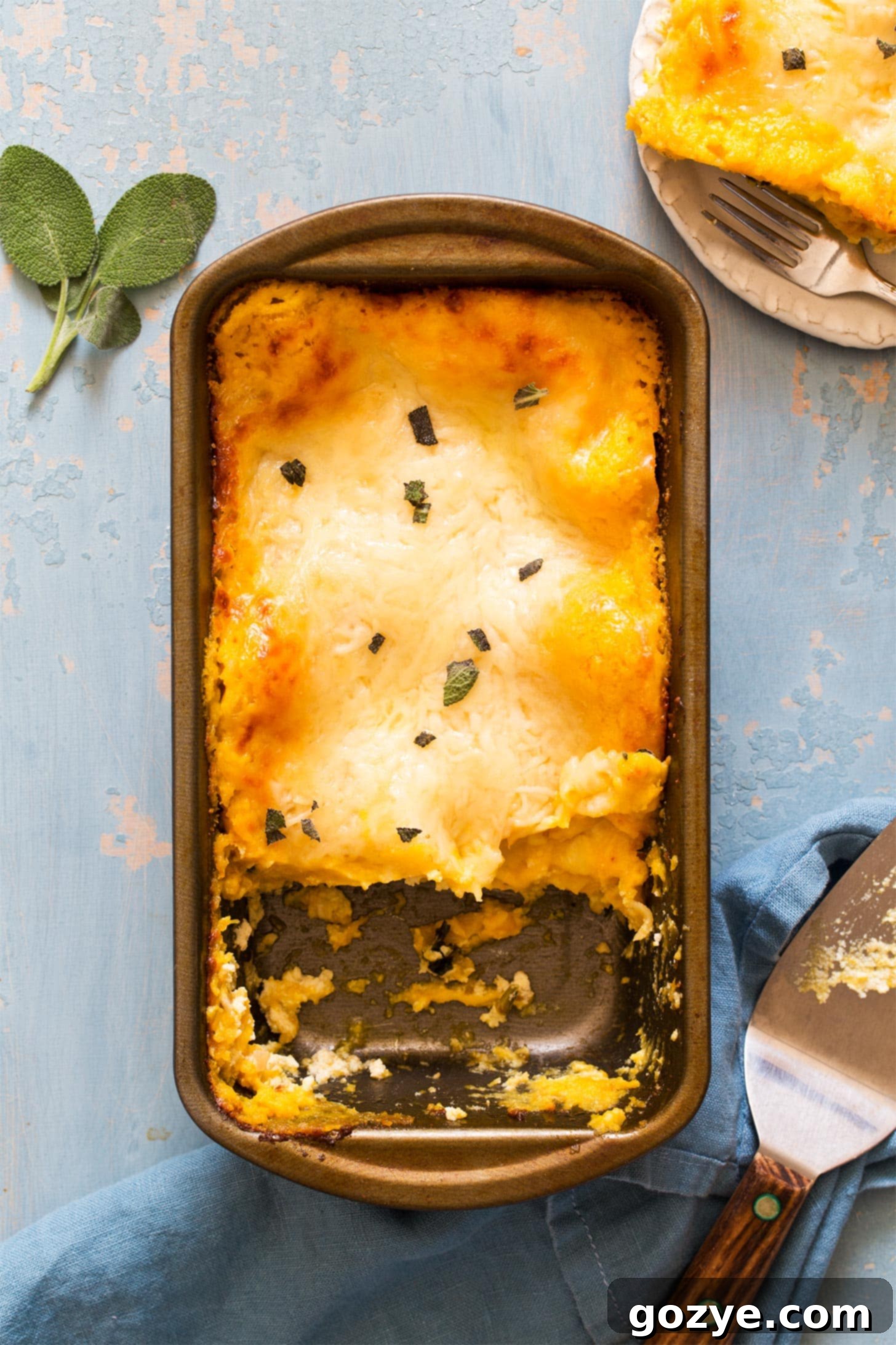Butternut squash lasagna in a loaf pan with a slice served