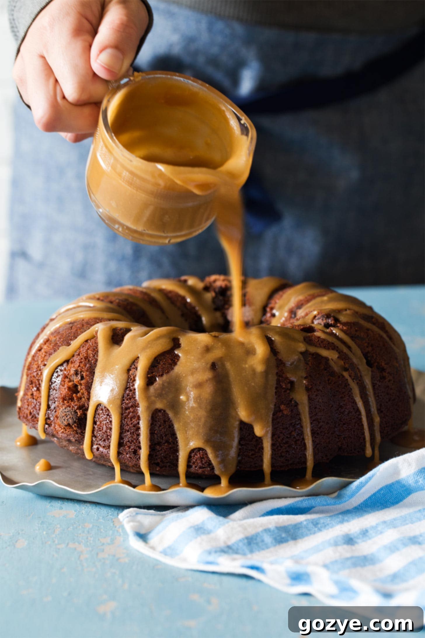 Drizzling caramel glaze over chocolate bundt cake for a beautiful finish