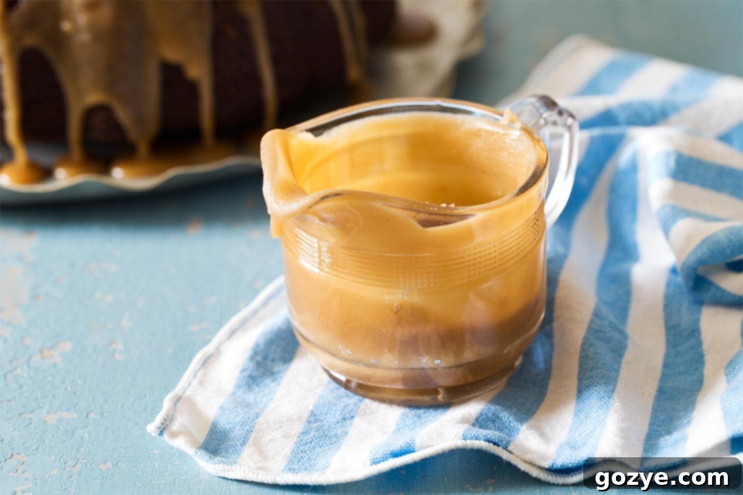 Glass pitcher overflowing with delectable Caramel Drizzle, ready for dessert topping